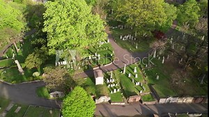 Tombstones, memorials, and graves in lovely garden cemetery. Aerial view at sunset.