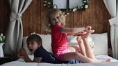 Cute sweet toddler children, tickling feet on the bed, laughing and...