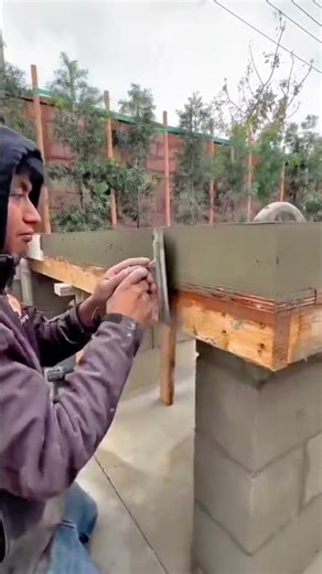 smoothing a concrete surface with a metal trowel for a high quality backyard table building project