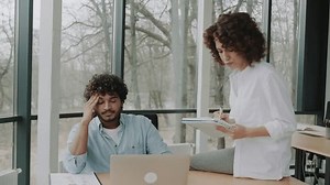 two employees in the office at the desktop swear annoyed. Stress and poor productivity at work