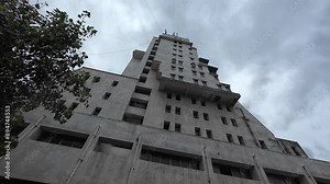 Empty residential building, recently built, surrounded by a cloudy sky, representing an abandoned architectural project.