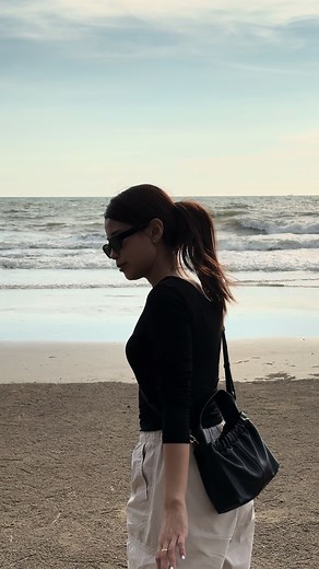 Woman Strolling on the Beach in Stylish Attire