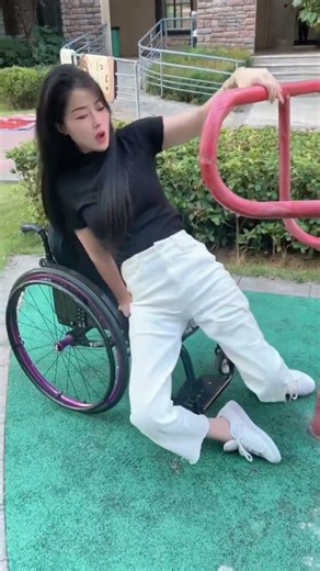 Belle paraplegic girl tries to use outdoor exercise equipment