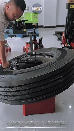 Truck drivers uses automatic tire changer machine to mount heavy truck wheel effortlessly