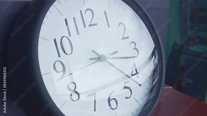 Closeup time-lapse footage of the clockwise moving in a wall clock from morning to dusk