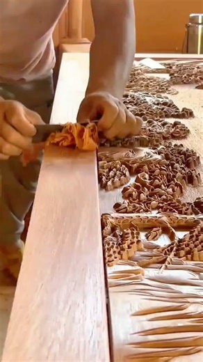 A craftsman using a hand planer to smooth the edge of a carved frame