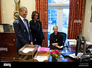 US President Barack Obama, First Lady Michelle Obama and Personal Secretary Anita Decker watch a video on Decker's computer monitor in the Outer Oval Office of the White House January 17, 2014 in Washington, DC Stock Photo - Alamy