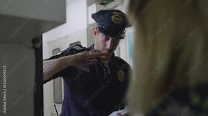 Police officer, investigator, or detective stands at a woman's front door, questioning her and writing notes in a small notebook. Witness statement, investigation, law enforcement, crime-solving, Cop.