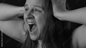 Black and white side view of crazy mad desperate middle-aged woman with loose long hair clutching head with hands, yelling. Stress, nervous breakdown, hopelessness, depression, negative emotions.