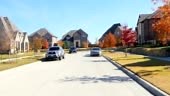 Front view driving through newly constructed residential houses in...