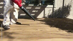 Painter cleaning deck before waterproofing. Paint prep. Painting contractor. Using blower to clean deck. Blower being used on construction site. Exterior painting. Paint company. Professional painter.