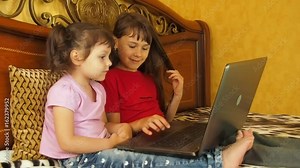 Little girls with laptop. Two little sisters are playing with a laptop.