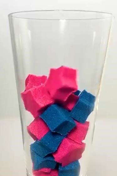 Pink and blue sand cubes in clear glass