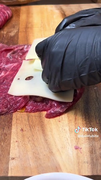 Flank Steak Pinwheels Recipe This recipe is a family favorite. This is how you cook flank steak to perfection and elevate your game. No more boring dinners and the secret is in the filling. Tender meat guaranteed. INGREDIENTS: 600 g beef flank steak 1 large onion 500g 6 slices of swiss cheese 90 g unsalted butter 1 tbsp sugar 4 oz. drinking red wine 5 -6 slices of pepperoni 1 cup mozzarella cheese salt and pepper to taste 4 tbsp of olive oil a handful of fresh oregano leaves kitchen twine 1/2 ts