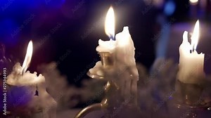 Candles flame close up on a dark background. Candle light close-up design. Melted Wax Candle Burning at Night. White Candles Burning in the Dark. Candlelight. Slow motion 4K UHD video