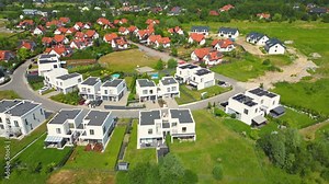 Aerial view of residential houses neighborhood and apartment building complex at sunset. Tightly packed homes, driveway surrounds green tree flyover Suburban housing development