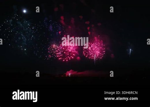 Colorful firework show over the field at the celebration at the nighttime. People silhouettes are visible. Slow motion. High quality 4k footage Stock Video Footage - Alamy