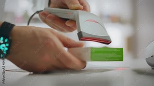 Medicine. A pharmacist uses scanner tools to dispense medications in the pharmacy department. In slow motion, young white man works behind a pharmacy counter, demonstrating professional skills, shelf