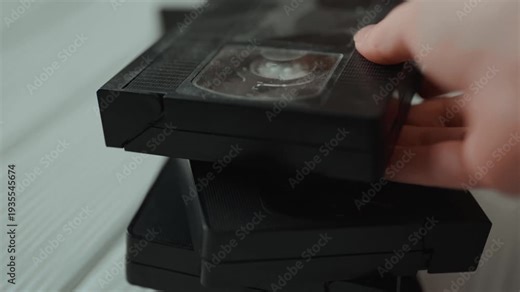 Stack of vintage VHS video cassettes with blank labels. Old analog media technology from 80s and 90s.