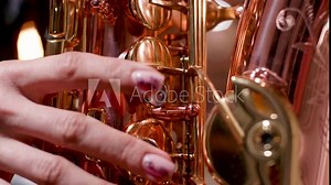 Female playing on a beautiful saxophone. Performing on a wind musical instrument.