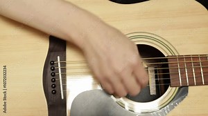 Hand Playing Acoustic Guitar Close-Up, person teaching beginner guitar techniques, guitarist giving rock or country music lesson in a cozy space