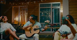 Mixed race man singing, playing guitar in merry friends party in backyard, 4K, Prores