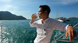 Portrait confident young asian man looking forward and smiling while standing on the yacht
