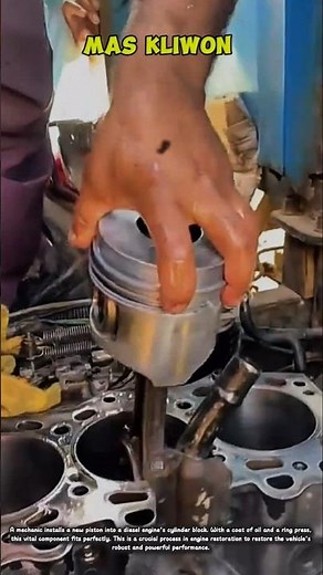 A mechanic installing a new piston into a diesel engine cylinder block.
