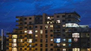 Evening sky from blue hour to night transition. Timelapse of window lights turning on and off. City, residential, urban, time lapse.
