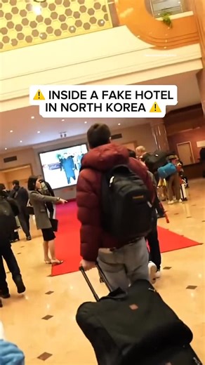People Secretly Films on Instagram: "They called it a “luxury hotel”… but something felt off the moment they stepped inside. Smiling bellboys. Perfect lighting. Red carpet rolled out like a movie scene. But behind the glass doors, it was all smoke and mirrors. No internet. No room keys. No other guests. Just portraits of leaders watching silently from every wall — and one hallway that was strictly off-limits. Tourists thought they were checking into a hotel. What they didn’t know was… the hotel