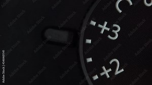 Extreme macro view of changing exposure compensation wheel indicators setting on mirrorless or dslr camera, detailed footage. Retro vintage style. Concept of photographic or filmmaker equipment.