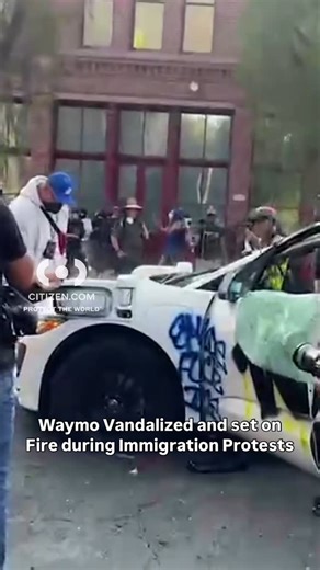 WATCH LIVE on CITIZEN: A spray-painted car is up in flames as tensions rise between demonstrators and police. Get real-time alerts, updates, live video, and more on @citizen 📲 #waymo #protest #la #dtla #immigration | Citizen