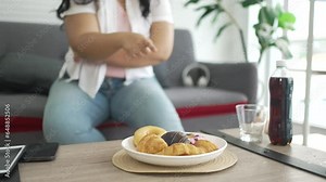 Plus size woman is eating donut.