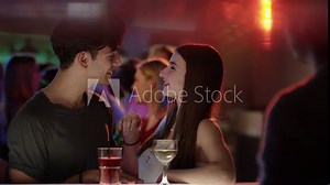attractive girl flirting with guy at bar in club