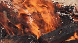 Extreme close-up still shot of an open funeral pyre with wind orange and yellow flames blowing on the fanning wind, Ganges River, India Stock Video