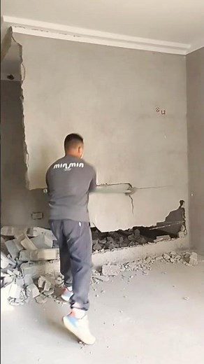 Demolition Crew Man Uses Sledgehammer to Take Down an Interior Wall