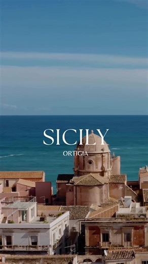Ortigia, the heart of Syracuse, Sicily There are places that feel like stepping into another time. Ortigia, the small island that forms the historic center of Syracuse, is one of them. Connected to mainland Sicily by two small bridges, Ortigia is a labyrinth of honey-colored stone streets, baroque balconies, hidden courtyards, and the endless blue of the Mediterranean surrounding you on every side. Here, history is not something you read about, it lives in every corner. In the morning, fishermen