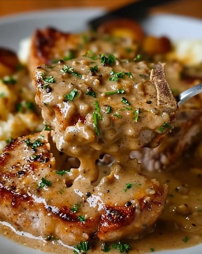 ULTIMATE Smothered Pork Chops in Creamy Ingredients 4 bone-in pork chops (about 1 inch thick) Salt and pepper, to taste 1/2 cup all-purpose flour 2 tablespoons vegetable oil 1 medium onion, sliced 3 cloves garlic, minced 2 cups chicken broth 1 cup heavy cream 1 teaspoon Worcestershire sauce 1 teaspoon dried thyme 1 teaspoon paprika 1/2 teaspoon garlic powder 1/2 teaspoon onion powder Fresh parsley, chopped (for garnish) Instructions Season both sides of the pork chops with salt and pepper. Dredg