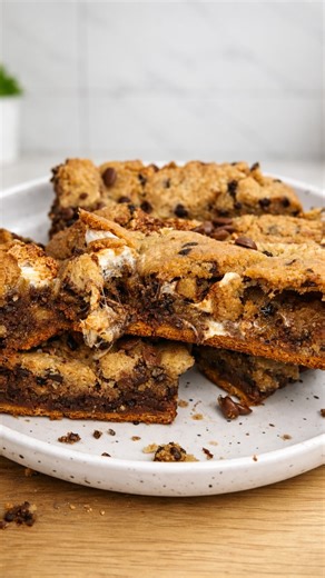 HIGH & RIPPED | Cooking • Travel • Fitness on Instagram: "Magic S’mores Cookie Bars 🍪🌱 Crispy edges, molten center, and that marshmallow pull that hits before you even take a bite. This is one of those desserts that turns into a core memory after the first square. POV: you wanted a quick dessert… and somehow baked something unreal. Chocolate, gooey marshmallows, soft cookie dough, and that classic graham crunch all stacked into one insane bar. Cozy, messy, and gone way too fast. ⸻ Ingredients 