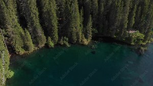 Alpine aerial landscape of the lake of Carezza in the Dolomites Italy, panning from the lake to the mountains.