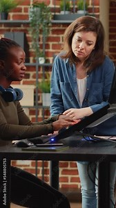 Vertical video: Multiethnic group of 3d artists developing digital interface in production agency office, working with creative software. Young coworkers creating digital electronics development.