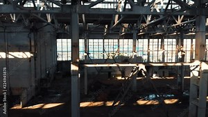 Abandoned and haunted industrial creepy warehouse inside, old ruined grunge factory building, shot from drone flying inside, toned