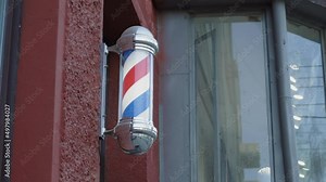 The movement of the Rotating Barbershop Pole on the street facade of the building. Attention-grabbing street advertising.