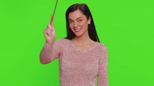 Magician witch young woman gesturing with magic wand making wish come true, casting magician spell