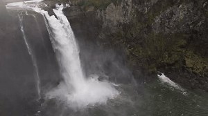 Snoqualmie Falls waterfall in Western Washington dropping into splash pool surrounded by rugged rockface