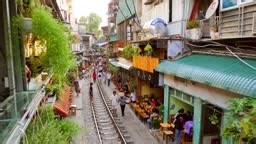 Narrow Train Street in Hanoi's Old Quarter with people on the tracks...