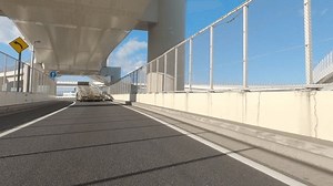 POV driving on the metropolitan expressway in Tokyo, Japan. Driving under the road signs as you turn the bend. Beautiful good weather, clear sky. Wangan Bayshore Route.