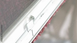 Close up shot of man's hands screwing by screw gun screwdriver bolts in aluminum profile. Using tools in manufacture of mosquito net for plastic windows. Vertical format video.