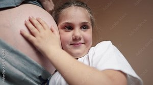 pregnant woman belly. a little girl hugs her mother belly. happy family baby pregnancy newborn concept. daughter baby listening to pregnant mother belly. happy family expecting newborn close-up