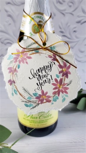 Make the perfect hostess gift for a New Year's Eve party! Add a little Handlettering and @plaidcrafts holographic Dimensional Magic to a watercolor wreath, attach with twine to a bottle of sparkly! . #plaidcreators #plaidcrafts #Handlettering #newyearseve #doodlecraftblog | Doodlecraft